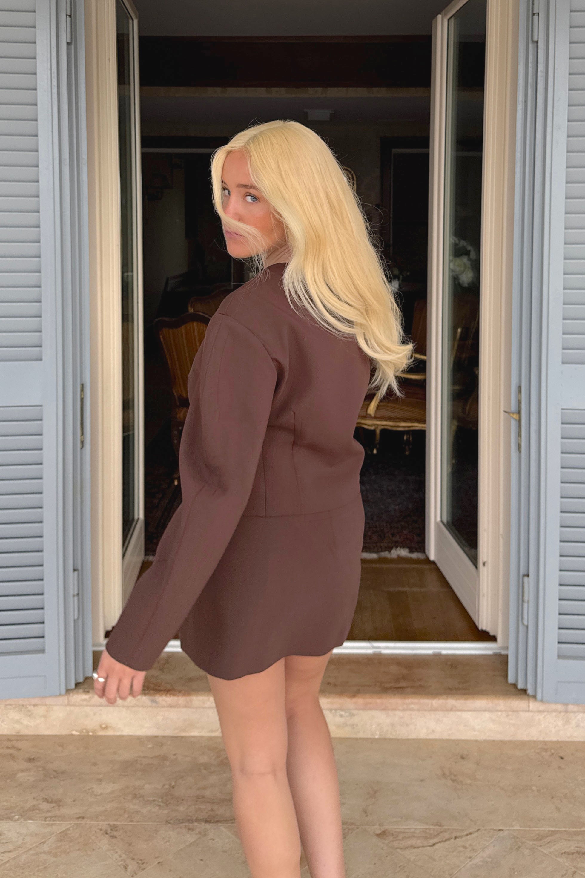 Woman wearing a long BHBD Livia warm blonde wig.