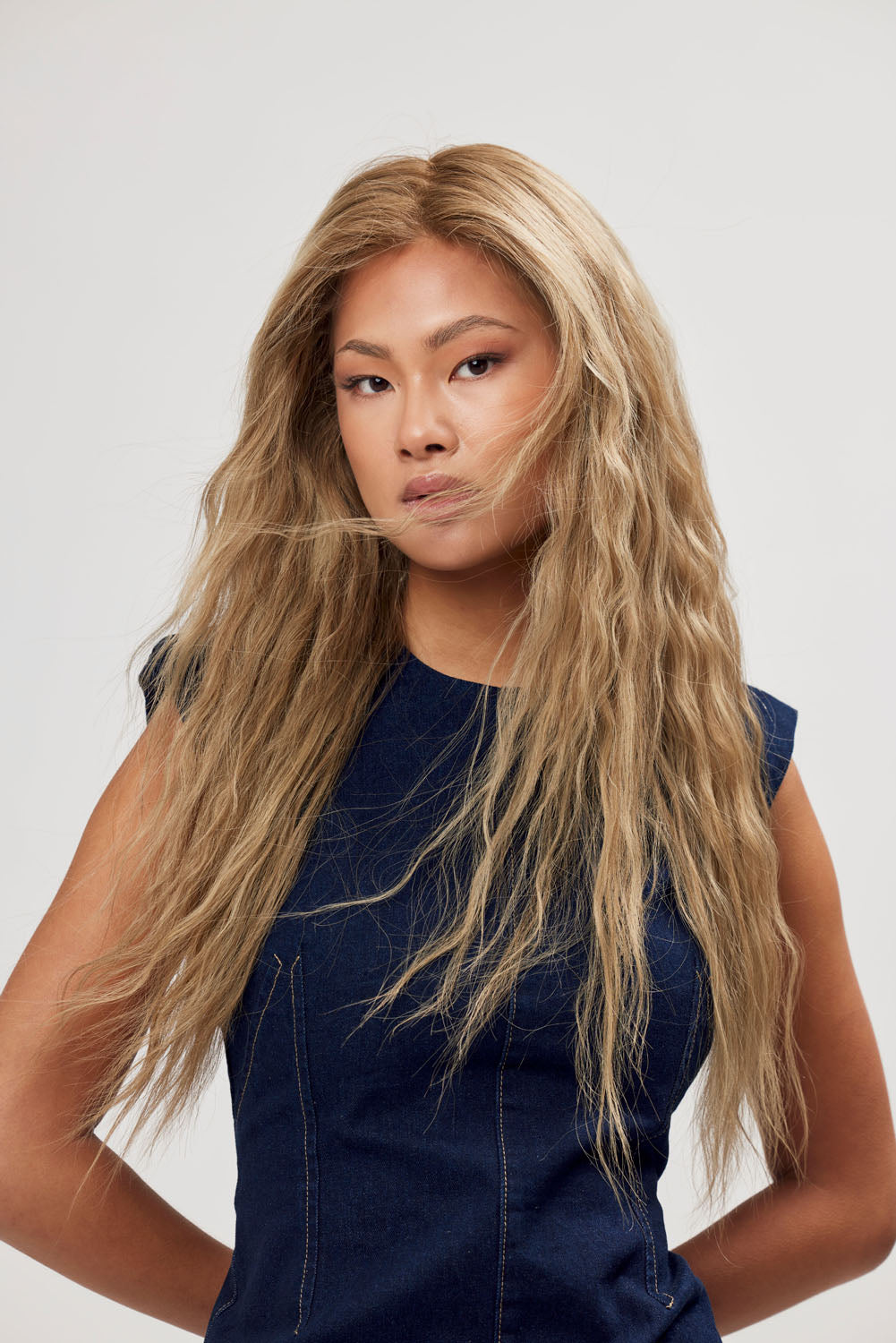 Model wears BHBD Scarlet Sovereign wig: 50cm in a natural blonde color and a dark blonde root with some well-placed lowlights. The hair is 100% Remy hair