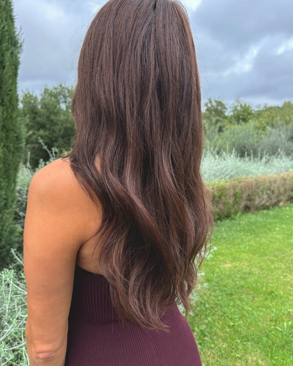 Woman wearing a BHBD Valentina wig. Long dark brown wig for natural look.