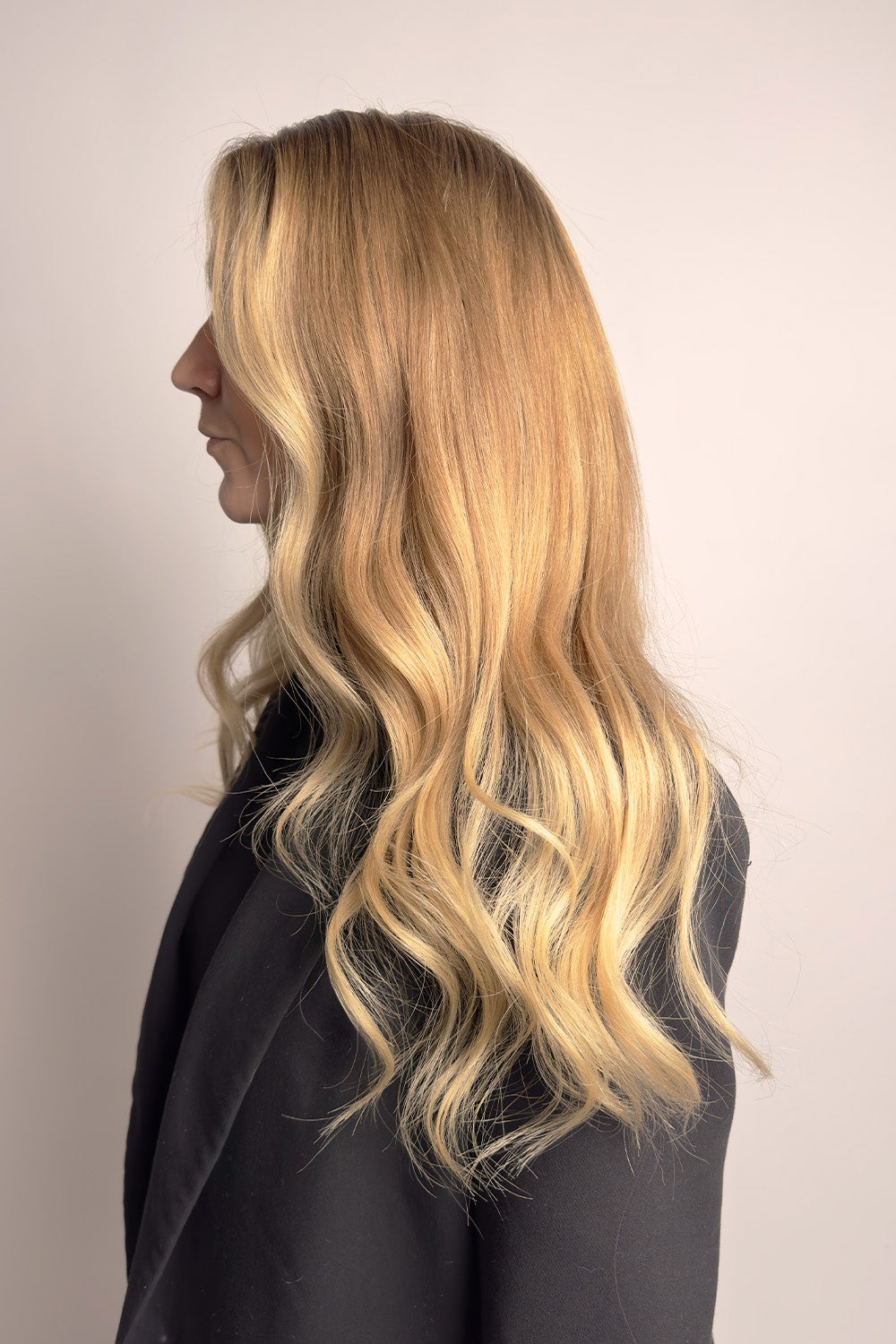 Modellen bär BHBD Static wig: 40cm, medium blond peruk med mörkare rötter och naturligt guldiga toner. En moneypiece i luggen som ramar in ansiktet. 100% äkta Remy hår av högsta kvalitet.