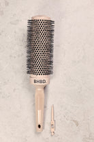 BHBD round brush with ergonomic handle and detachable sectioning tool, designed for precise styling and efficient blow-drying, placed on a neutral background.